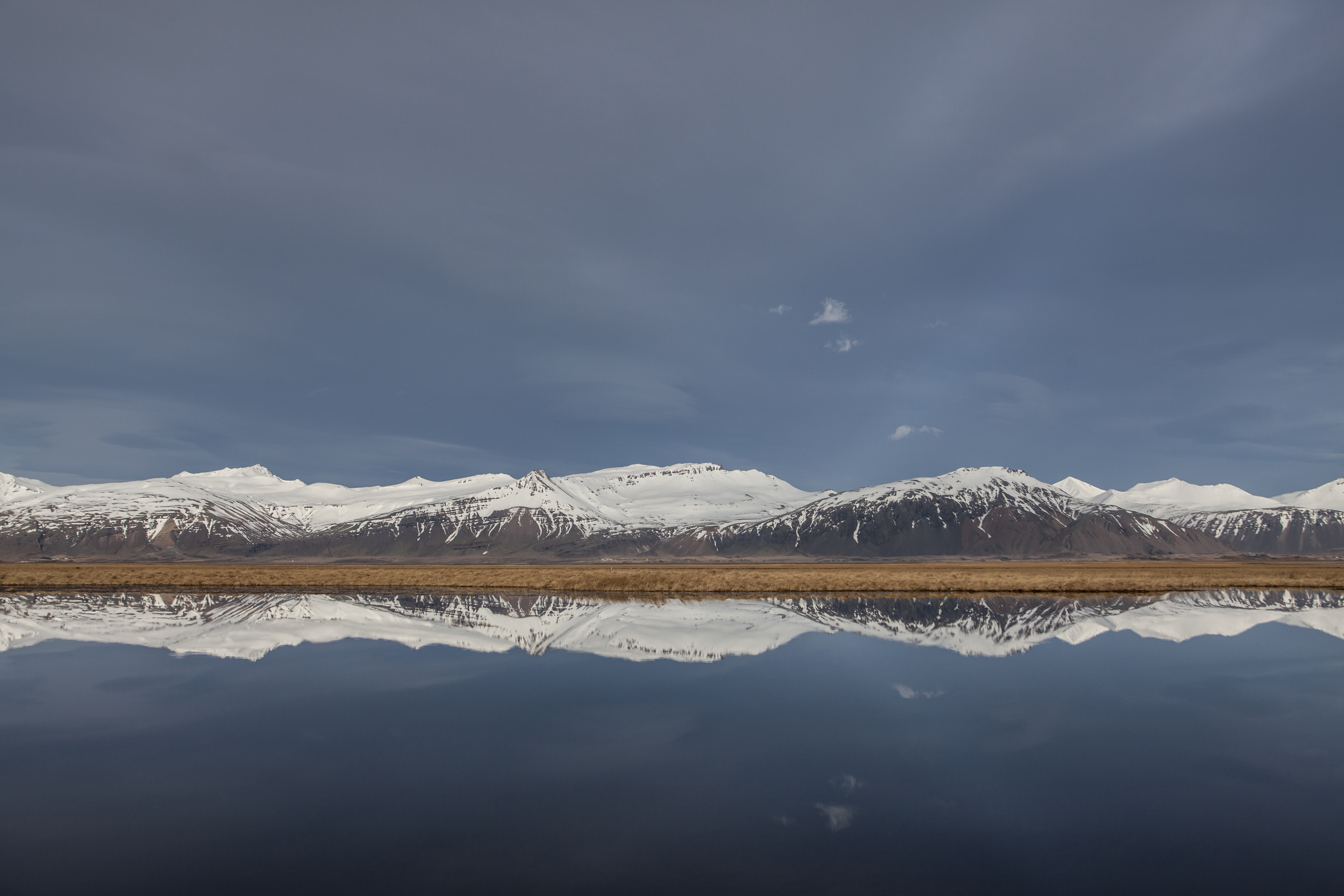 Snow-capped mountains perfectly reflected in still water