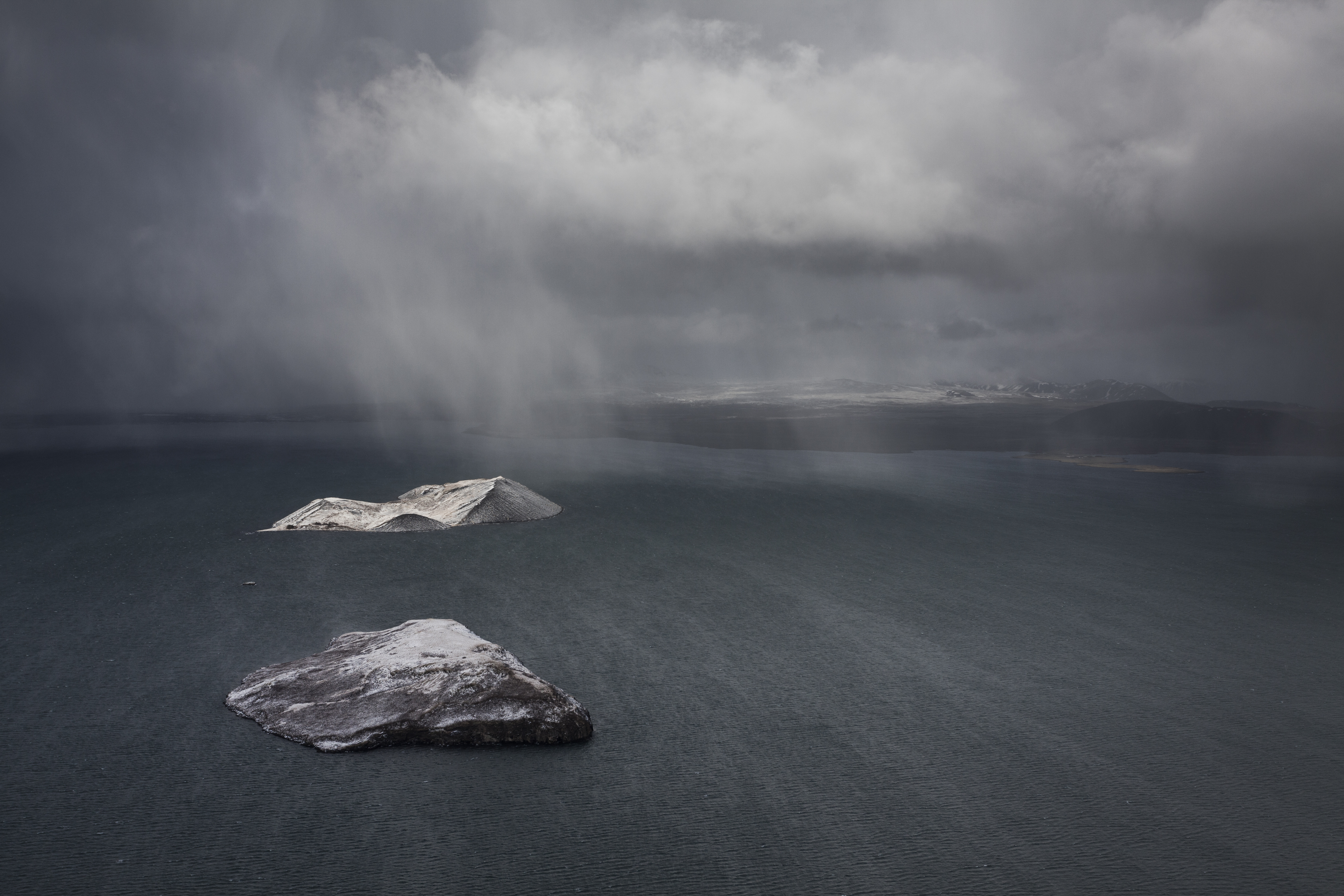 Two snow-capped islands in a stormy grey sea